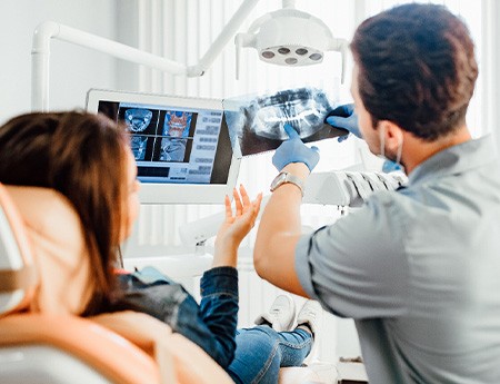 Dentist showing large sample implant to patient