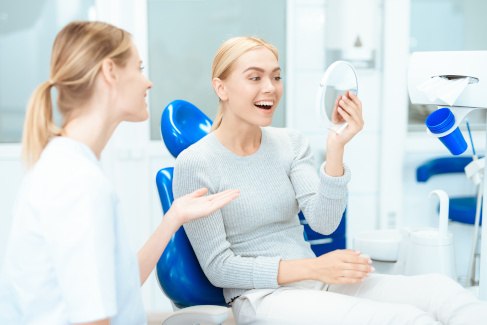 A woman admiring the results of her cosmetic dental work
