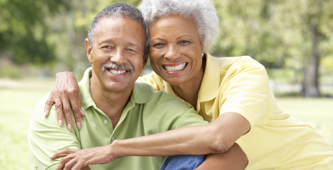 Man and woman smiling after restorative dentistry with dental crowns and fixed bridges