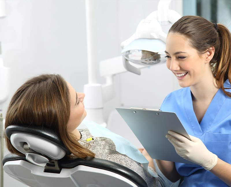 Dental team member and patient reviewing dental insurance coverage