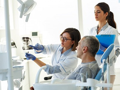Patient in Rochester at the dentist talking about dentures