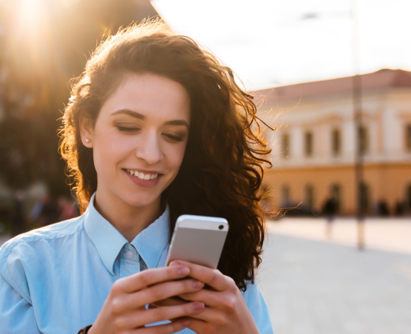 Woman using her smartphone to search for the best dentist in Rochester Minnesota