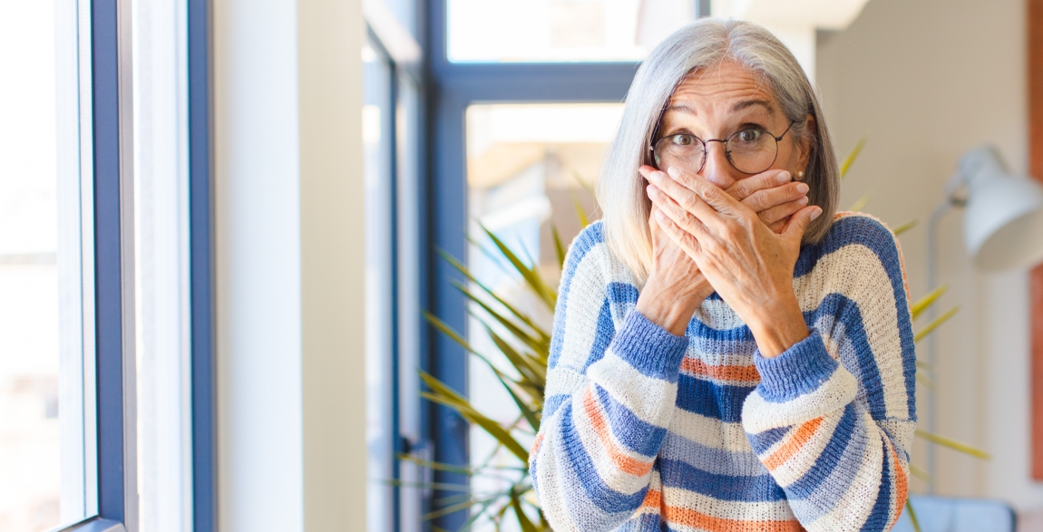 Woman in need of emergency dentistry covering her mouth