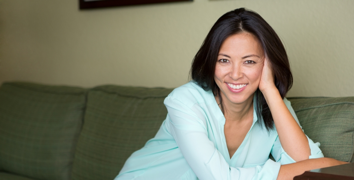 Woman smiling after replacing missing teeth