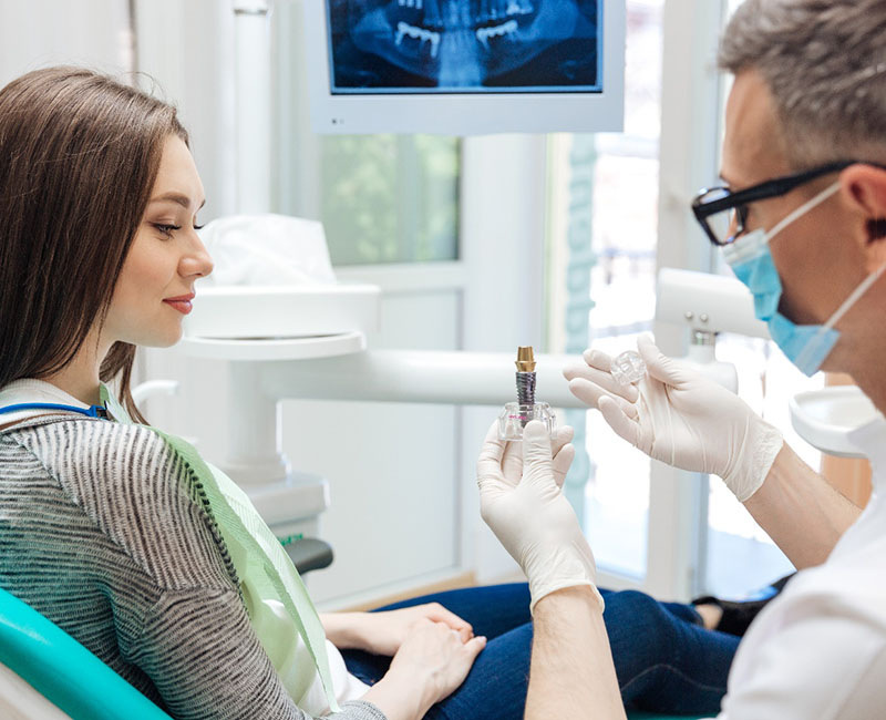 a dentist in Rochester explaining dental implants to a patient