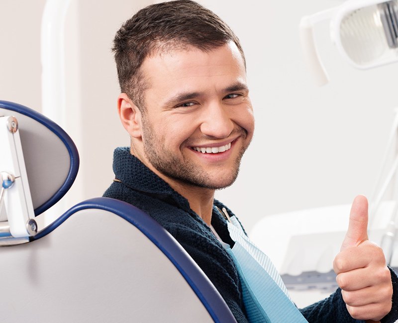 Male dental patient giving a thumbs-up