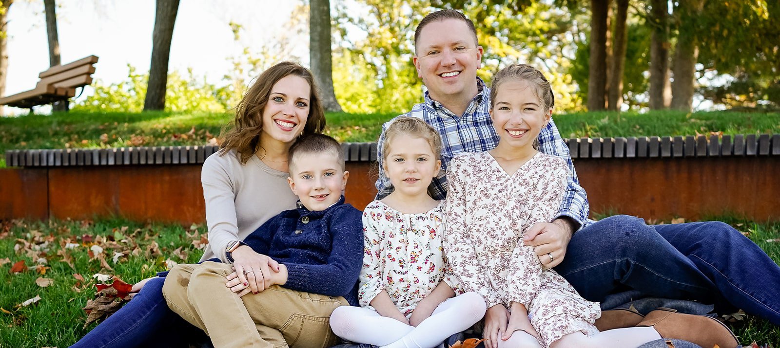 Dentist in Rochester Minnesota smiling outdoors with wife and three children