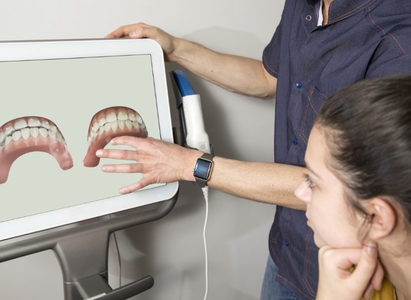Dentist and patient viewing digital dental impressions on computer screen