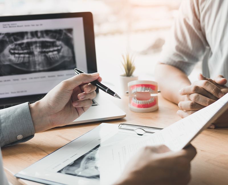 Dentist and patient reviewing treatment plan for complete tooth loss