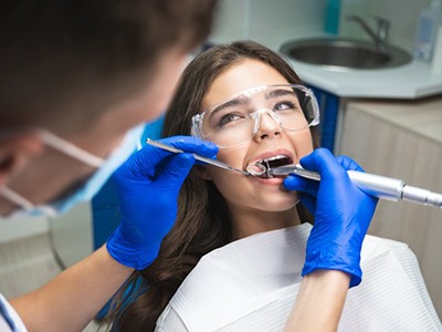 Dentist scaling a patient’s teeth