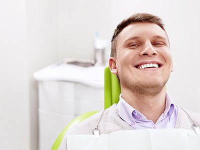 Male dental patient sitting back and smiling