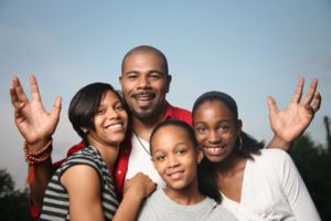 family of four smiling and hugging