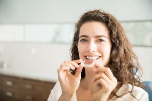 person smiling with Invisalign aligners