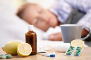 person sleeping with cold remedies next to them