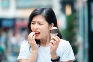 Woman with sensitive teeth eating ice cream