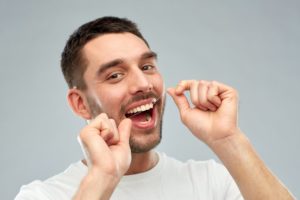 Happy man flossing healthy teeth