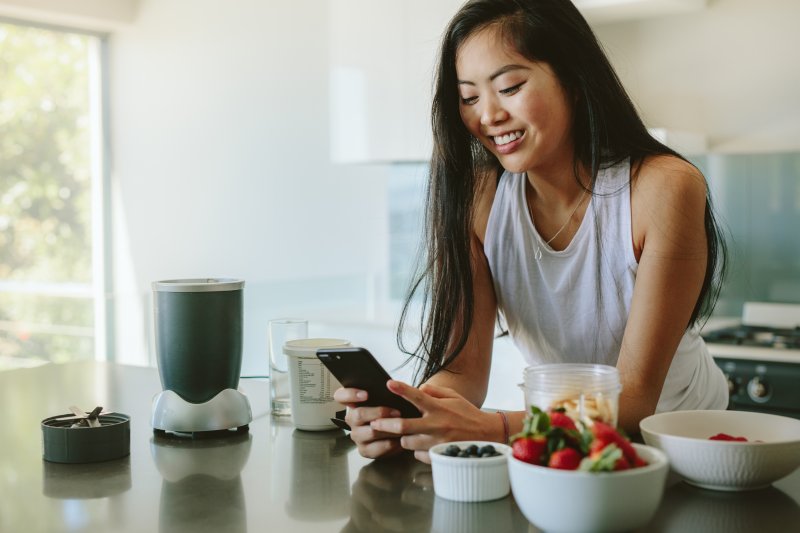 Woman smiling while looking up TikTok Recipe