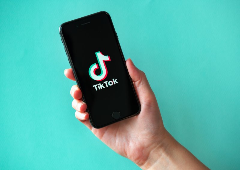 Person holding up phone with TikTok app open