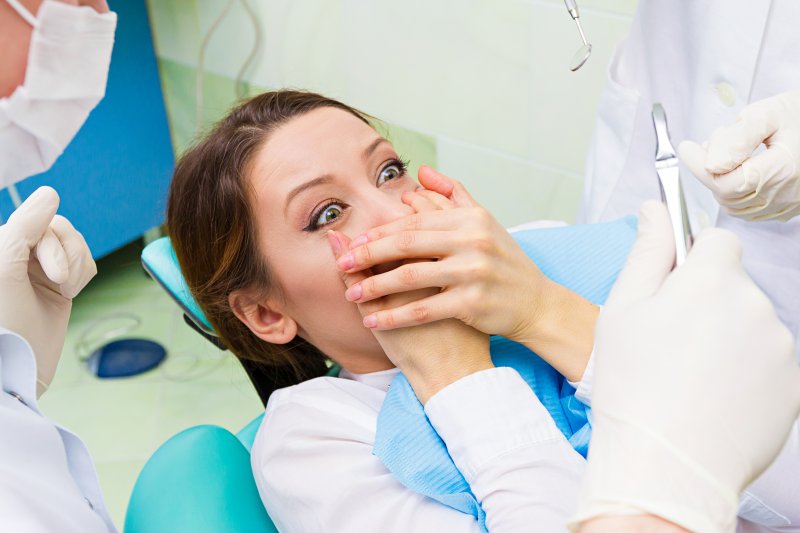 patient covering mouth at the dentist in Rochester