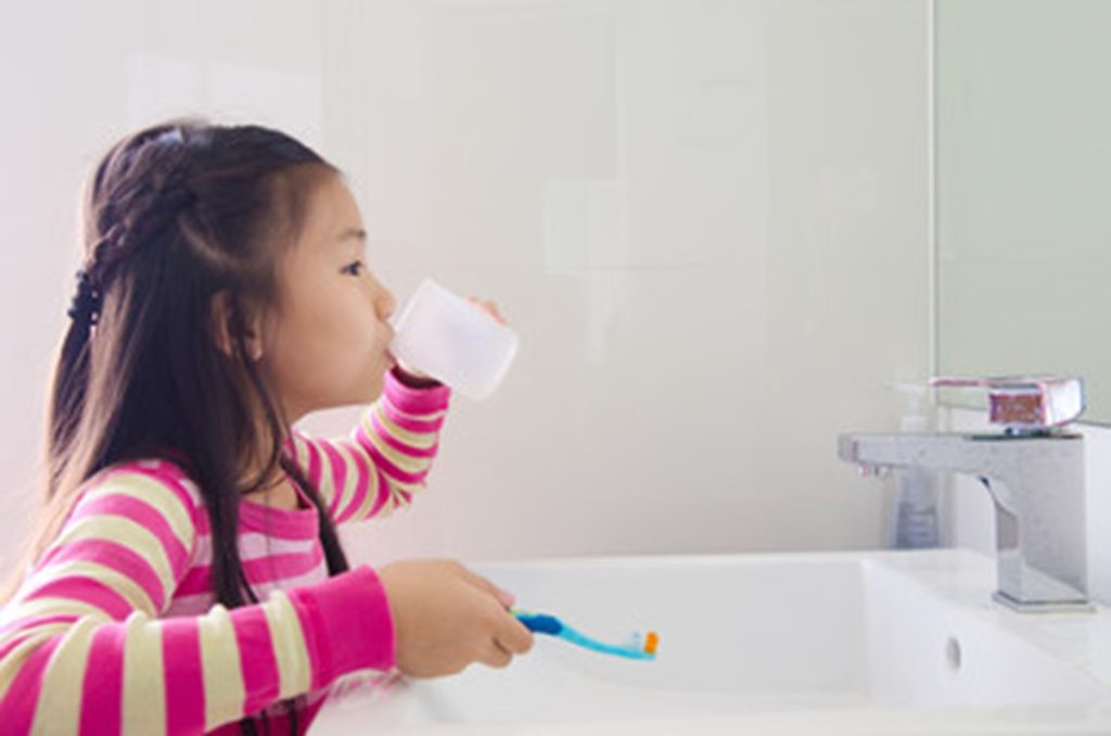 Girl rinsing her mouth after brushing.