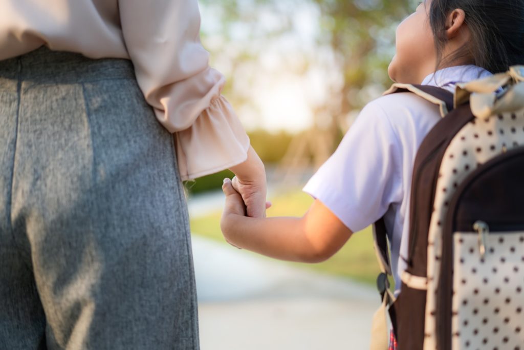 Closeup of parent and child walking to school together