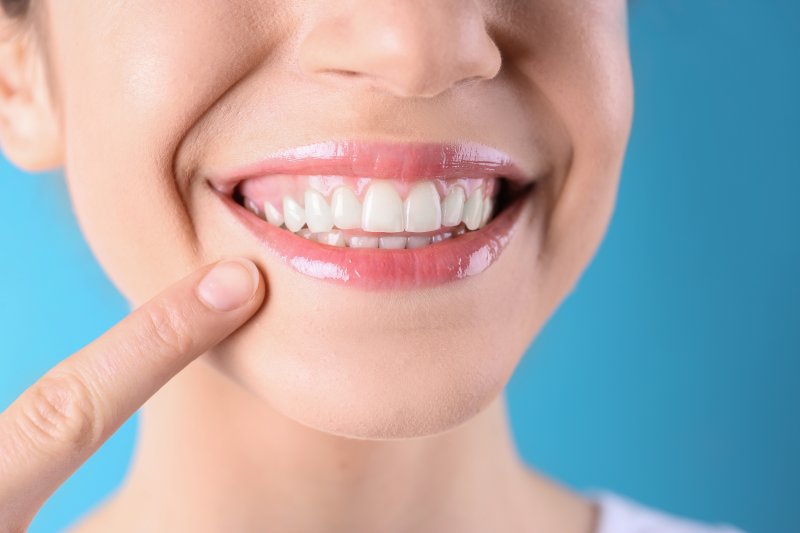 person pointing at yellow teeth in Rochester