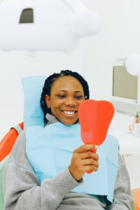 Woman in dentist’s chair looking in mirror