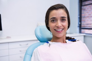 Female dental patient smiling and sitting in chair