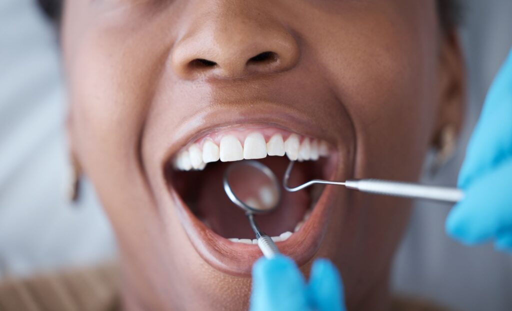 A woman having her teeth cleaned by a dental hygienist