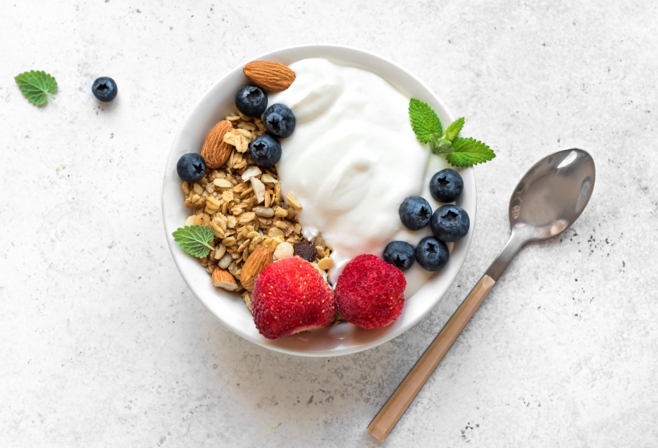 Bowl of yogurt topped with fruit, and a spoon